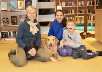 Gail Murphy (left) brings Wally to the library to work with kids like Isabelle, age 12, and Joly Evan, age 8