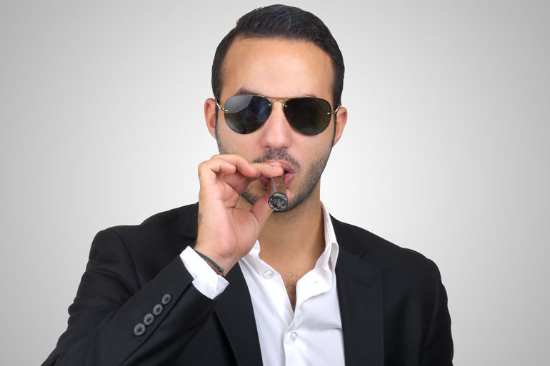 Man smoking cigar while wearing sunglasses