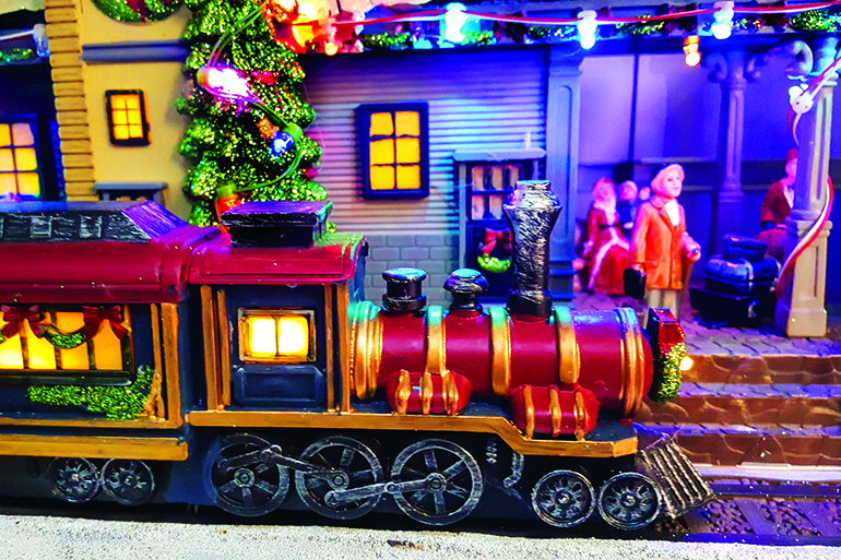 Christmas time miniature of street with a train in the foreground