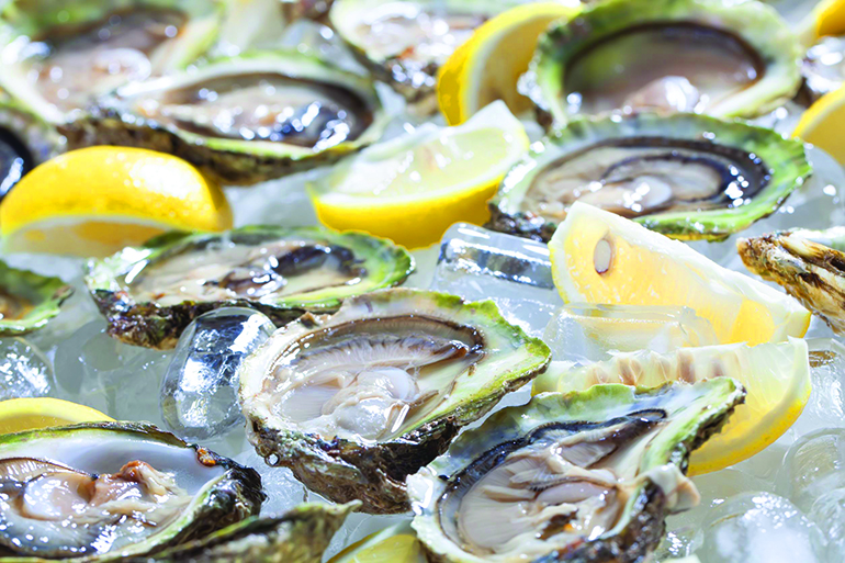oysters in a bowl with lemons.