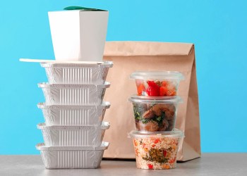 Food in various takeout containers on blue background