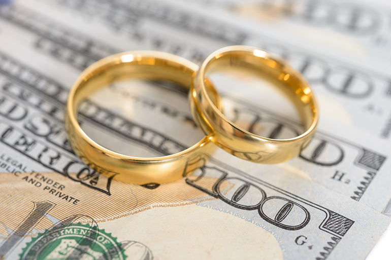 Close-up Of Wedding Ring On Us Dollar