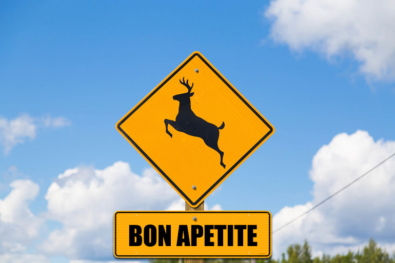 Deer crossing sign with "Bon Apetite" sign under it