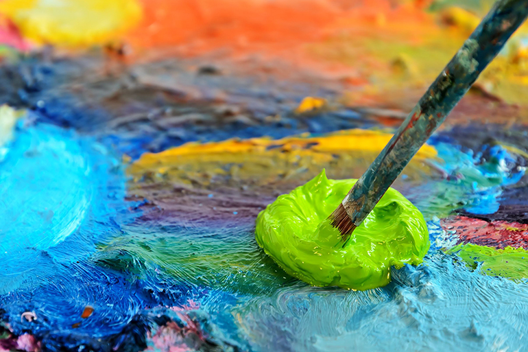 palette with paint and paintbrush, shallow depth of field.