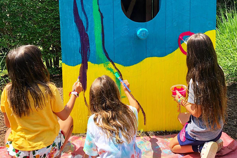 Shine campers painting a birdhouse