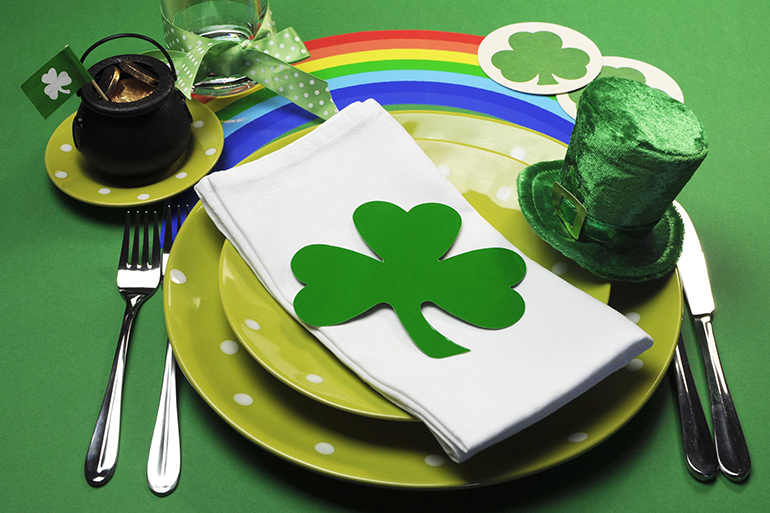 st patricks day party table dinner setting with rainbow, leprechaun hat and shamrocks