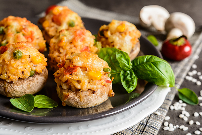 Mushrooms stuffed with rice, tomato, pea, corn and topped with mozzarella