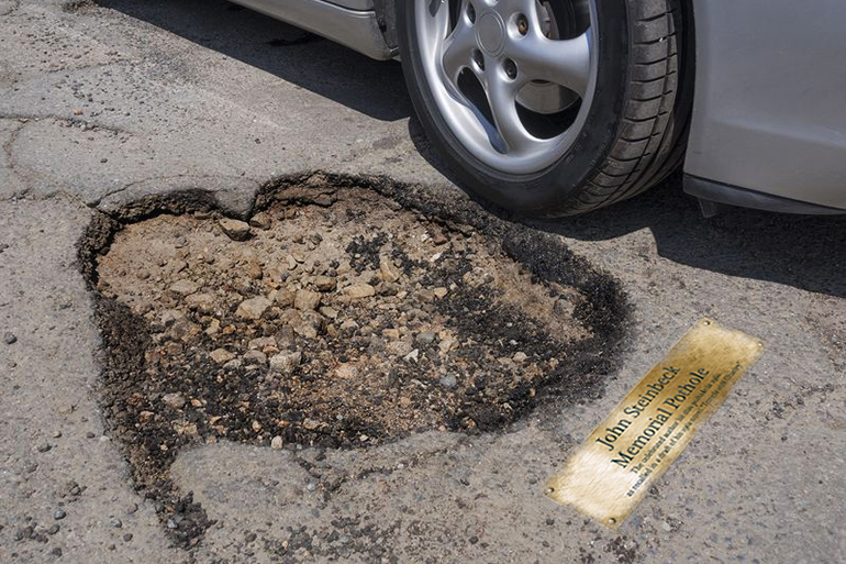 Render of the proposed John Steinbeck Memorial Pothole - brass plaque next to pothole with car passing