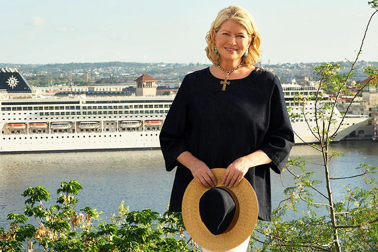 Martha Stewart stands in front of MSC Cruises cruise ship in a beautiful setting