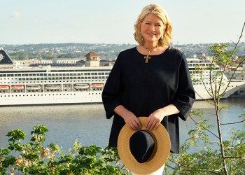 Martha Stewart stands in front of MSC Cruises cruise ship in a beautiful setting