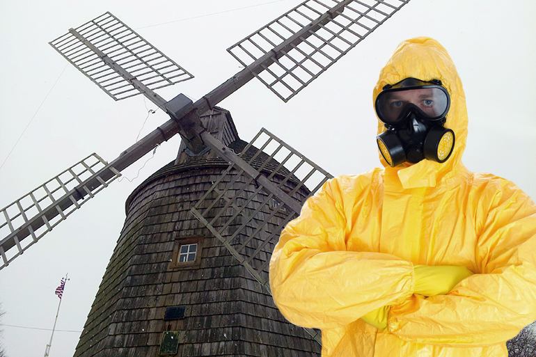 Guy in yellow hazmat suit with arms crossed in front of the Water Mill windmill