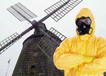 Guy in yellow hazmat suit with arms crossed in front of the Water Mill windmill