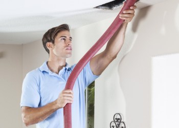 Man cleaning air ducts in home.