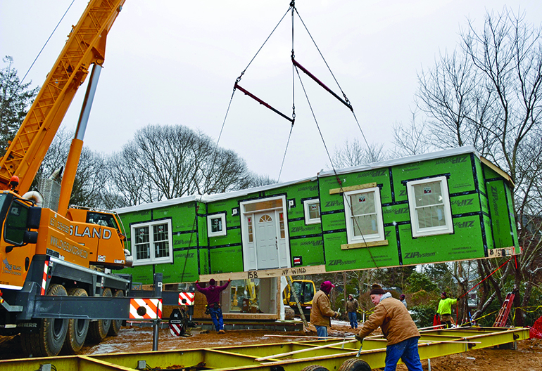The front of a house being carefully placed, Photo: Barbara Lassen