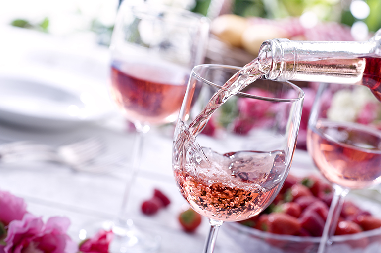 Close up of Rose wine being poured at a picnic setting.