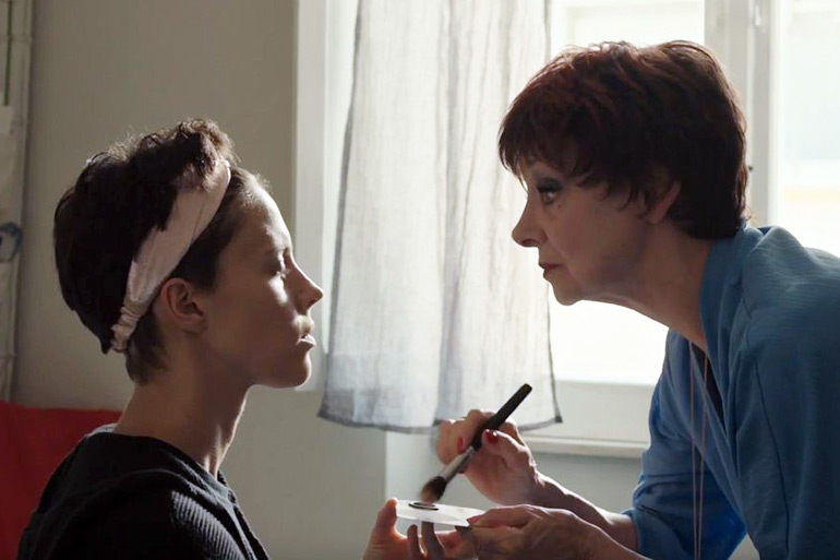 Carolina has make-up applied in anticipation of her husband's funeral in "Laughing"