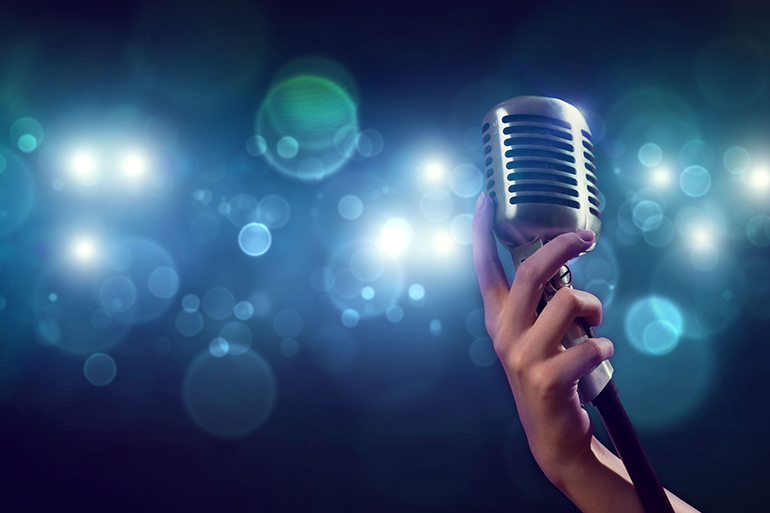Close up of female hand on blurred background holding microphone
