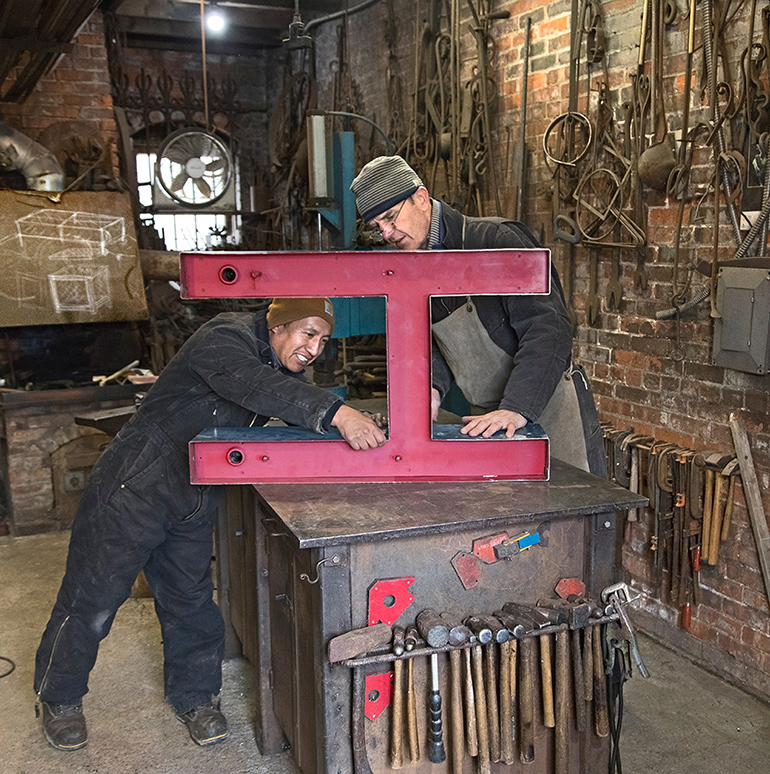 Battle and Franklin Paucar work on the Sag Harbor sign