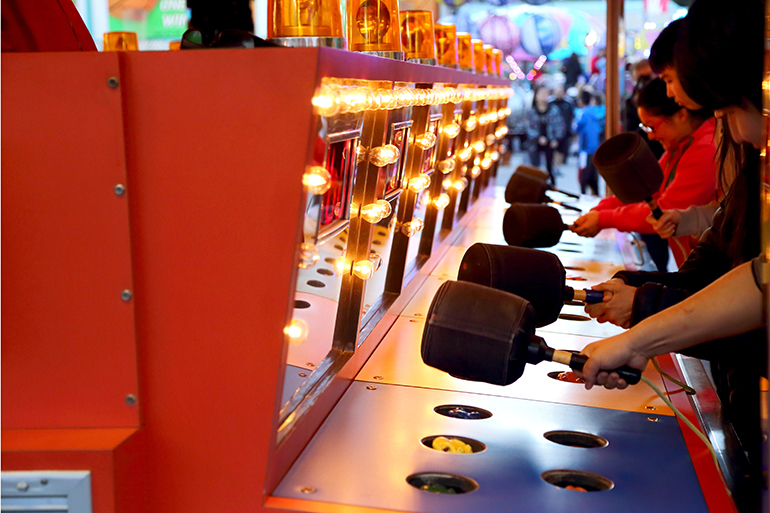 People playing whack game at carnival