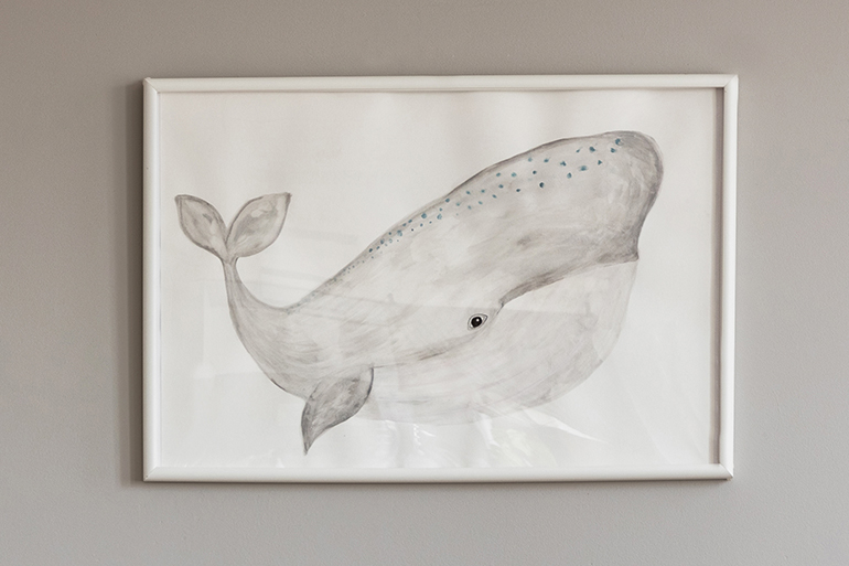 Grey whale on poster in classy baby room interior with white wooden rocking chair, rocking horse, crib and scandinavian ladder, copy space on empty wall