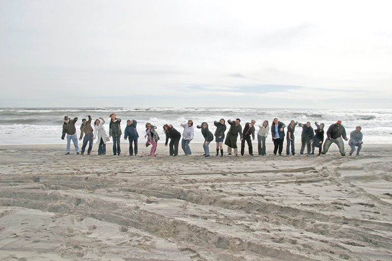 Dan's Papers staff holding the Great Ecuadorian Eel on the beach