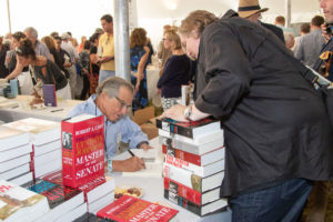 Robert A. Caro signing stack of books for fan