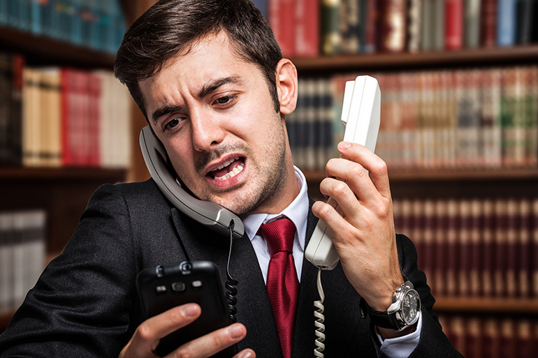 Stressed businessman talking on many phones at once