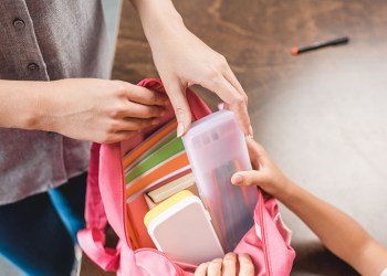 cropped shot of mother and daughter preparing backpack with scho