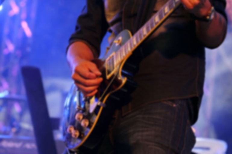 blurred musician playing guitar in concert