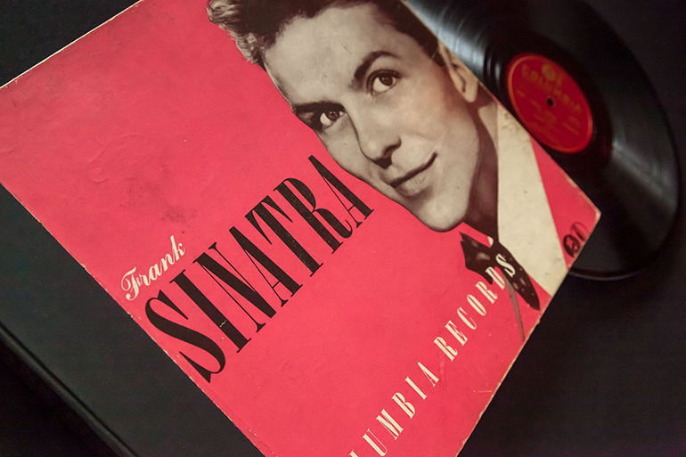 ctober 11, 2018: 1940s era Frank Sinatra 78 RPM records on a black background.