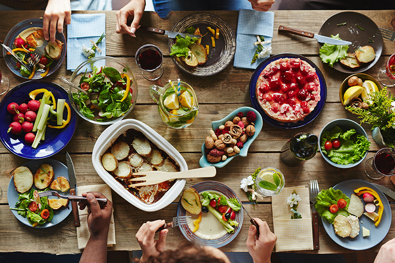 Several people eating dinner by table