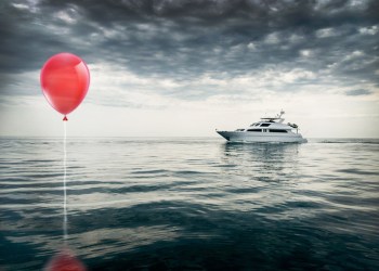 Red balloon at sea with boat