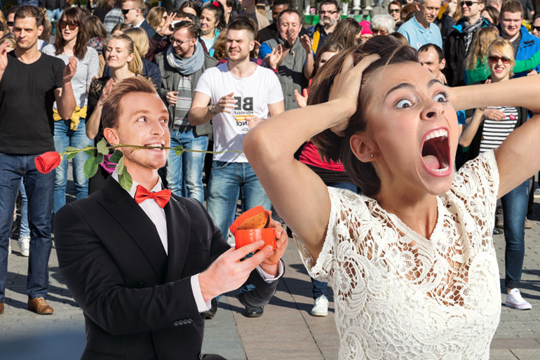 Man proposing to woman who is screaming in terror at flash mob behind them