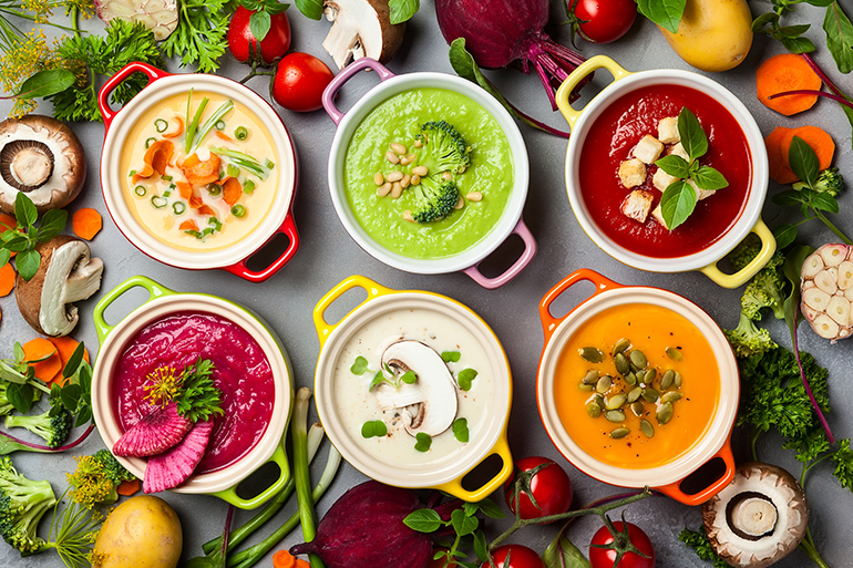 Variety of colorful vegetables cream soups and ingredients for soup. Top view. Concept of healthy eating or vegetarian food.