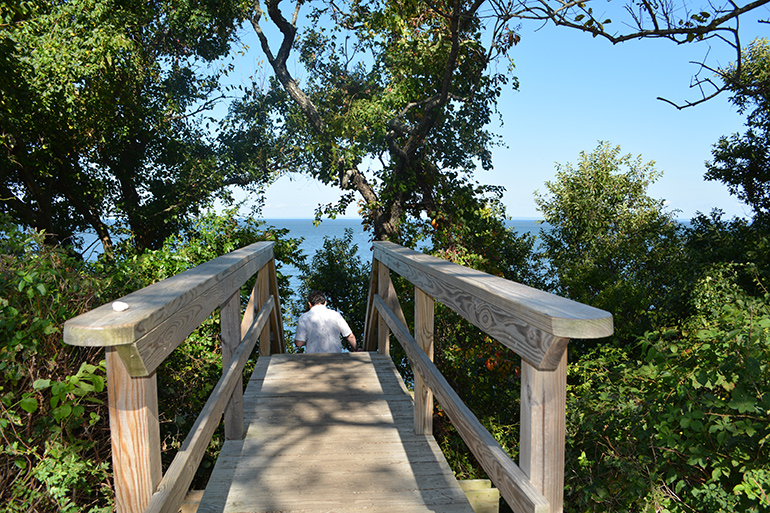Man descending wooden stairs to beach in Orient