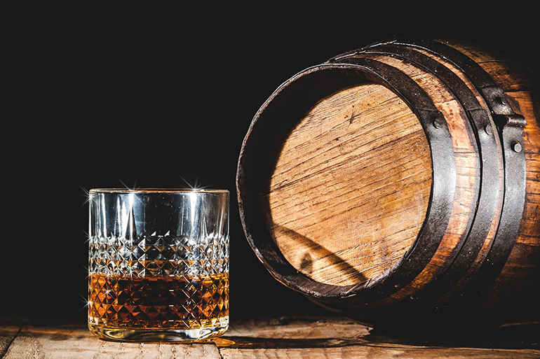 Strong alcohol on a wooden table and barrel
