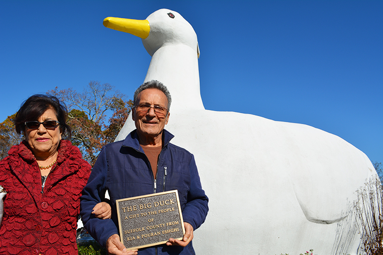 Pouran and Kia Eshghi holding the plaque honoring their gift of The Big Duck to Suffolk County