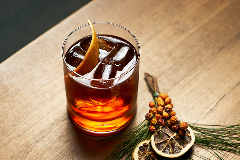 Alcohol whiskey cocktail or cognac with cola citrus and ice cubes on wooden table background