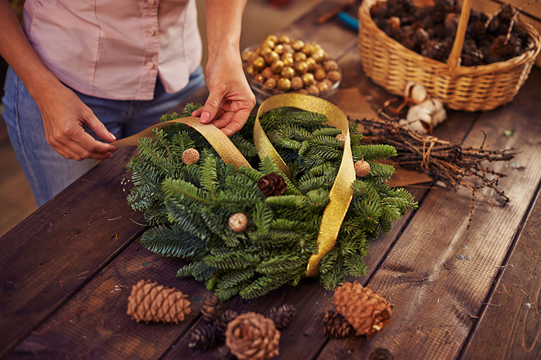 Woman decorating coniferous wreath