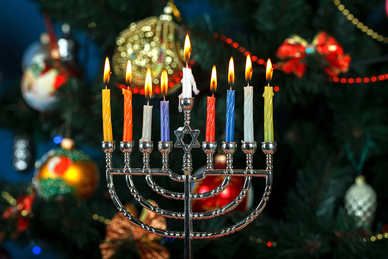 Menorah with candles for Hanukkah on the background of the New Year tree. Studio Lighting
