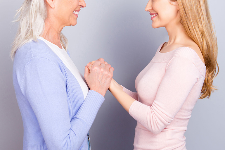 Two charming adorable wonderful dreamy darling dear beautiful cheerful excited joyful mama and kind friendly attentive sensitive daughter holding hands looking at each other isolated gray background