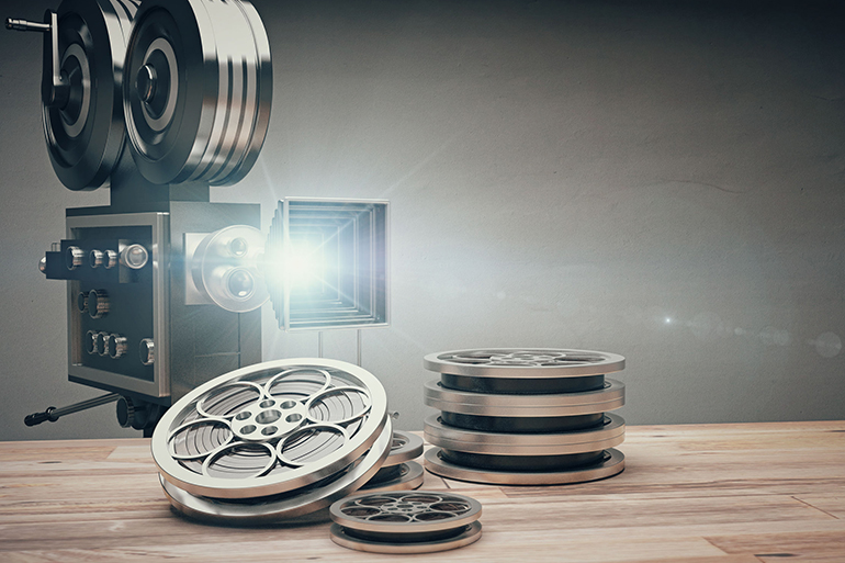 Vintage old movie camera and film cartridge on a wooden table