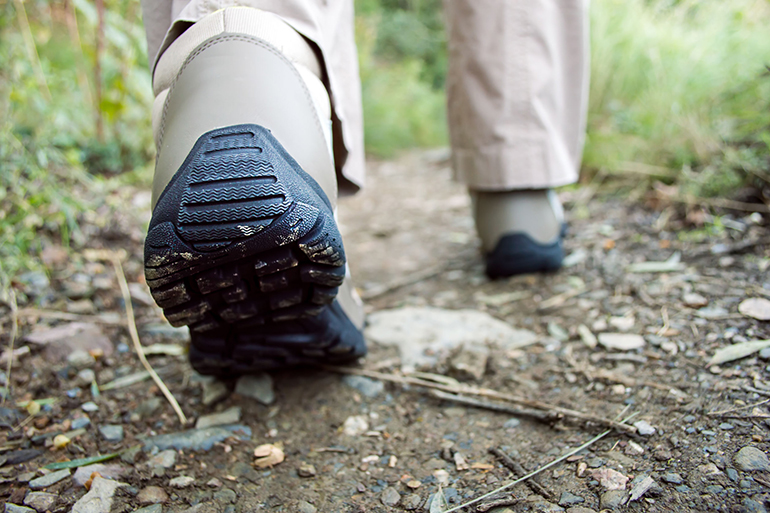 Cropped rear view of a hiker walking along a trail