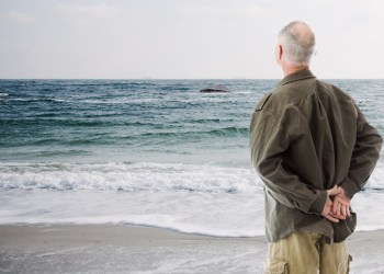 Old Man McGumbus watches his bunker floating out to sea from beach