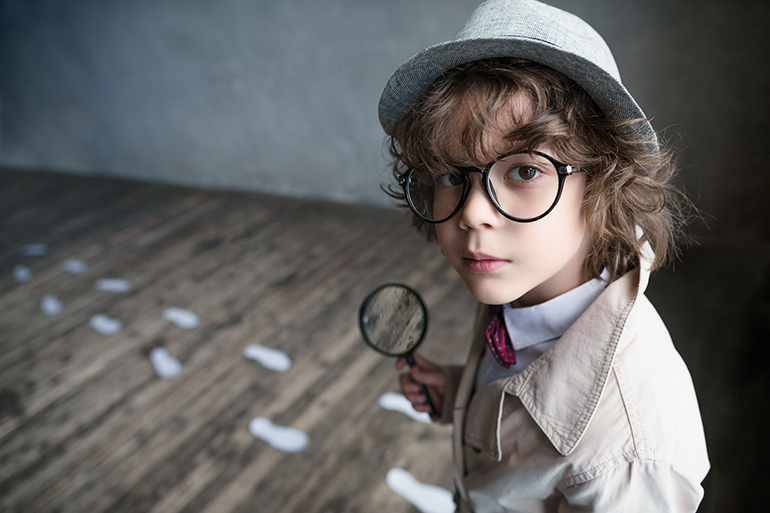 Little detective with a magnifying glass