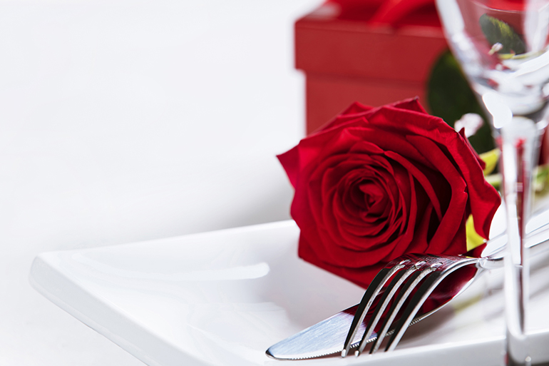 Valentine's Day or Romantic dinner concept. Valentine day or proposal background. Close up view of restaurant table with romantic table place setting. Copy space