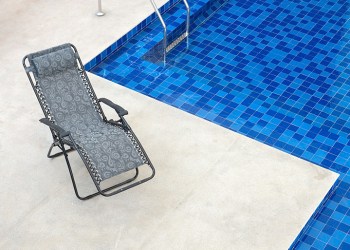 reclining chair along a swimming pool