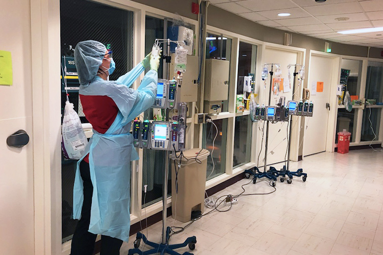 Stony Brook University Hospital monitors COVID-19 patient IV from outside their room on 18 South ICU