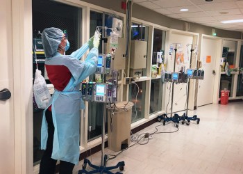 Stony Brook University Hospital monitors COVID-19 patient IV from outside their room on 18 South ICU