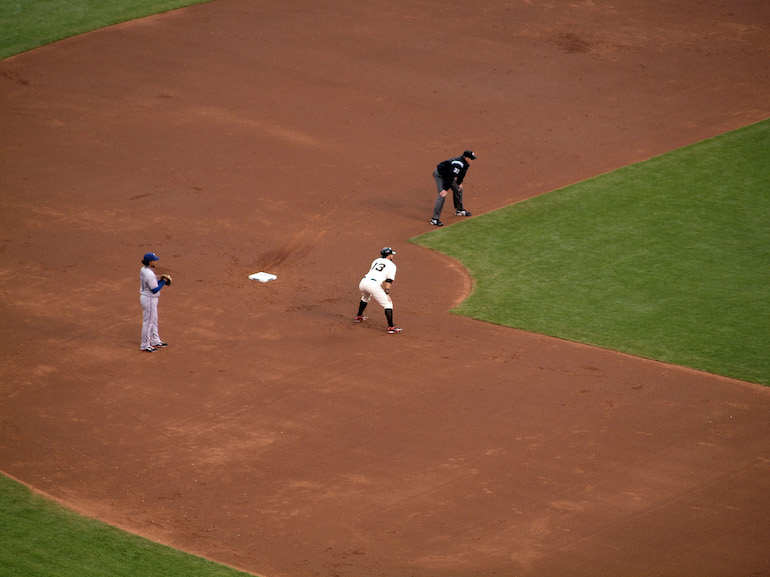 Baseball players standing at least six feet apart